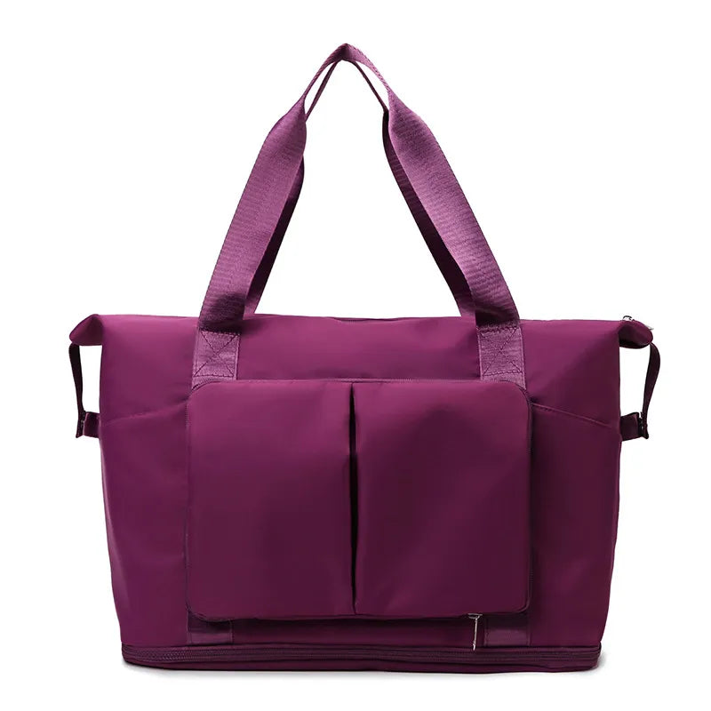 Plum purple foldable travel tote with two exterior front pockets and top handles.