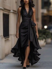 Black satin high-low ruffled maxi dress with a cinched waist and halter neckline.