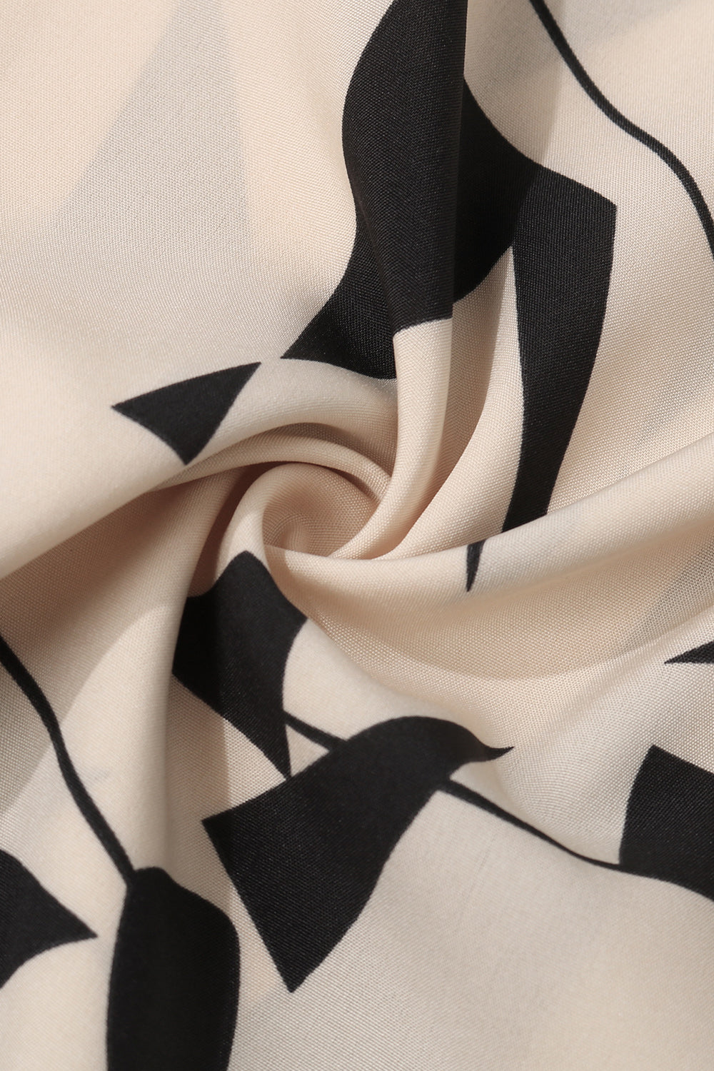 Cream blouse with bold black geometric print and voluminous sleeves.