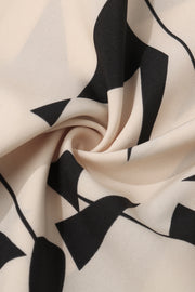 Cream blouse with bold black geometric print and voluminous sleeves.