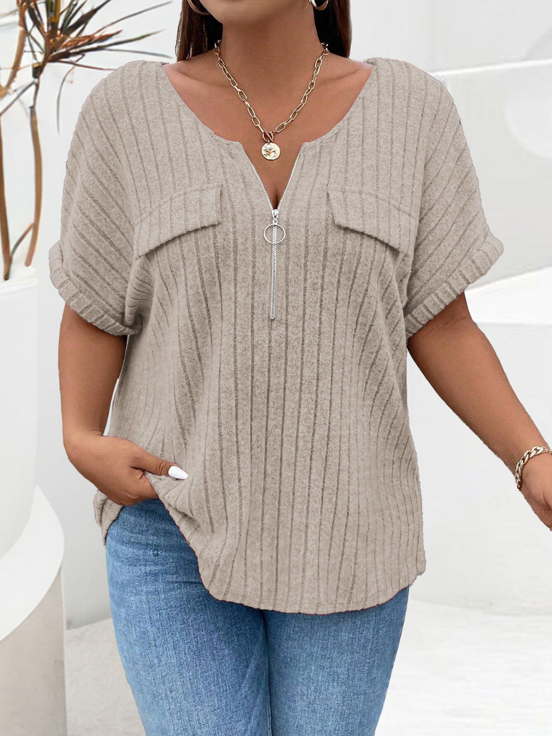 Khaki ribbed knit henley with short sleeves, zip neckline, and chest pockets.