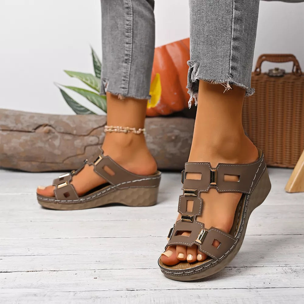 Brown open-toe wedge sandals with decorative gold accents and a comfortable cork sole.