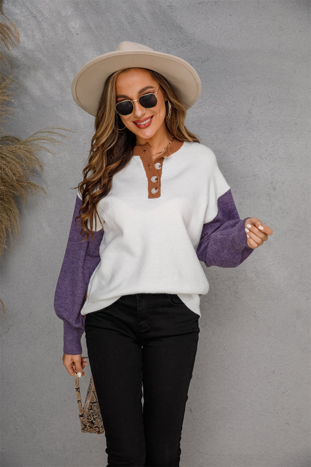 Colorblock henley knit sweater with white body, brown neckline, and purple sleeves.