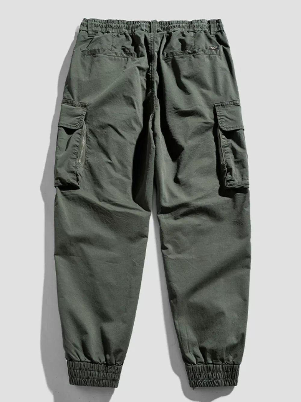 Army green cargo joggers with flap pockets and elastic cuffs.