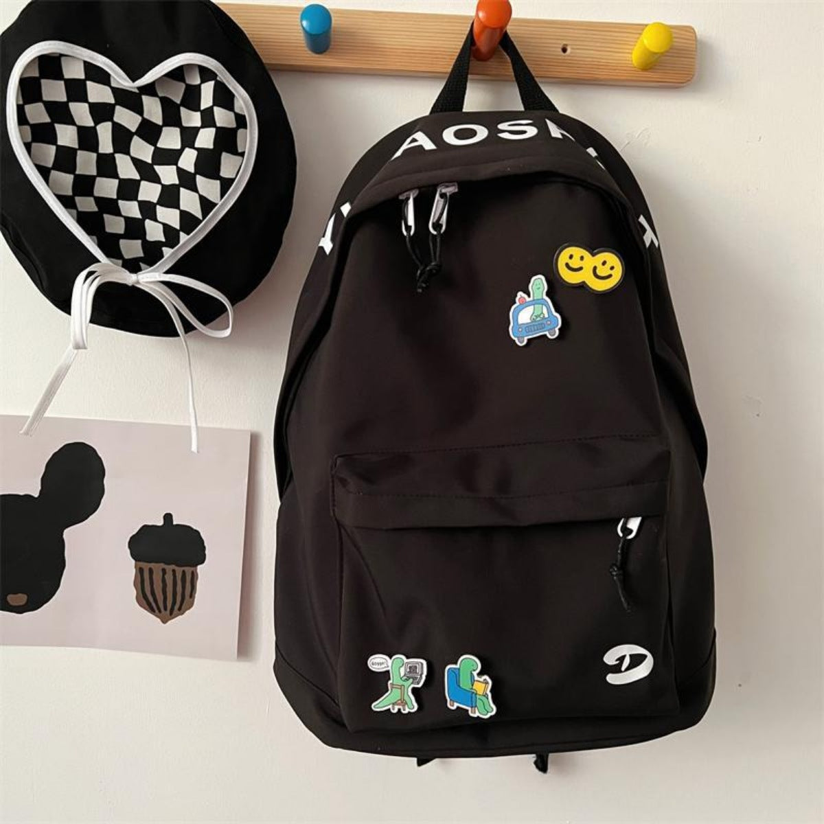 Black nylon backpack with utility pocket and fun cartoon patches.