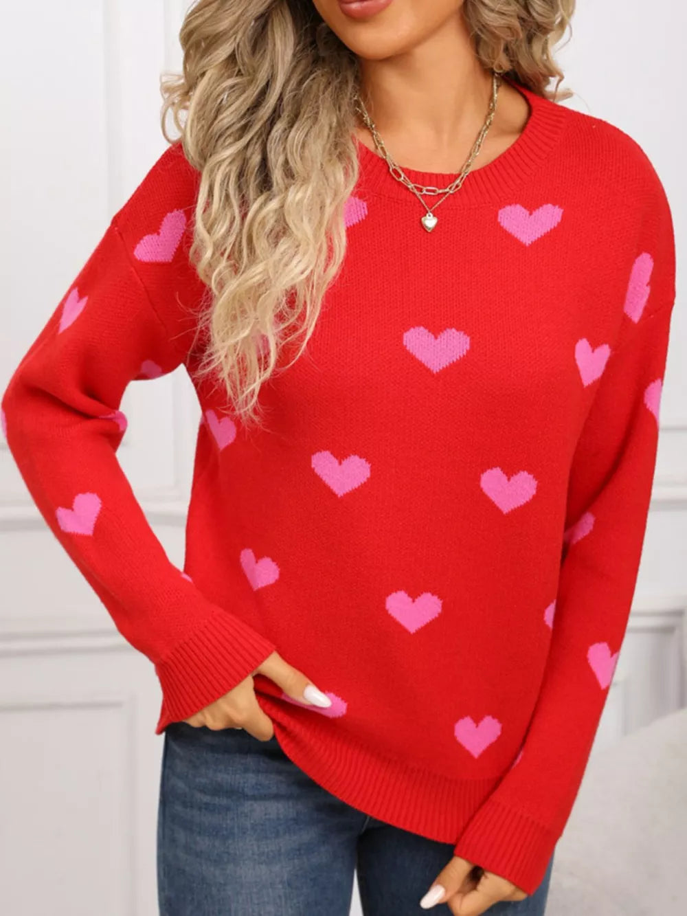 Red acrylic knit sweater with pink hearts, crew neck, and long sleeves.