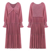 Smocked V-neck tiered maxi dress in dark pink with long sleeves and ruffled cuffs.