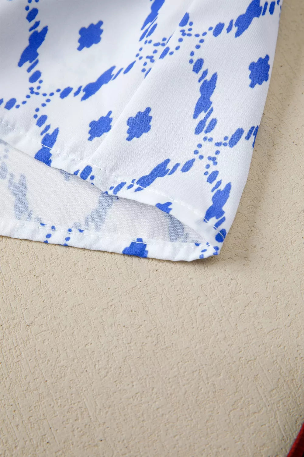 Patchwork babydoll maternity overshirt in white with blue abstract pattern and puff sleeves.
