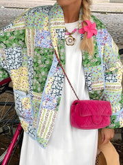 Floral quilted patchwork jacket in green and pastel floral prints with a light blue trim.