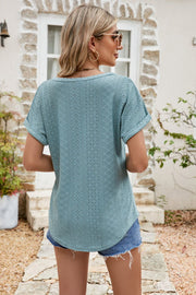 Teal perforated sleeve tee with rolled cuffs and a relaxed fit, styled with denim shorts.