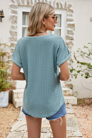 Teal perforated sleeve tee with rolled cuffs and a relaxed fit, styled with denim shorts.