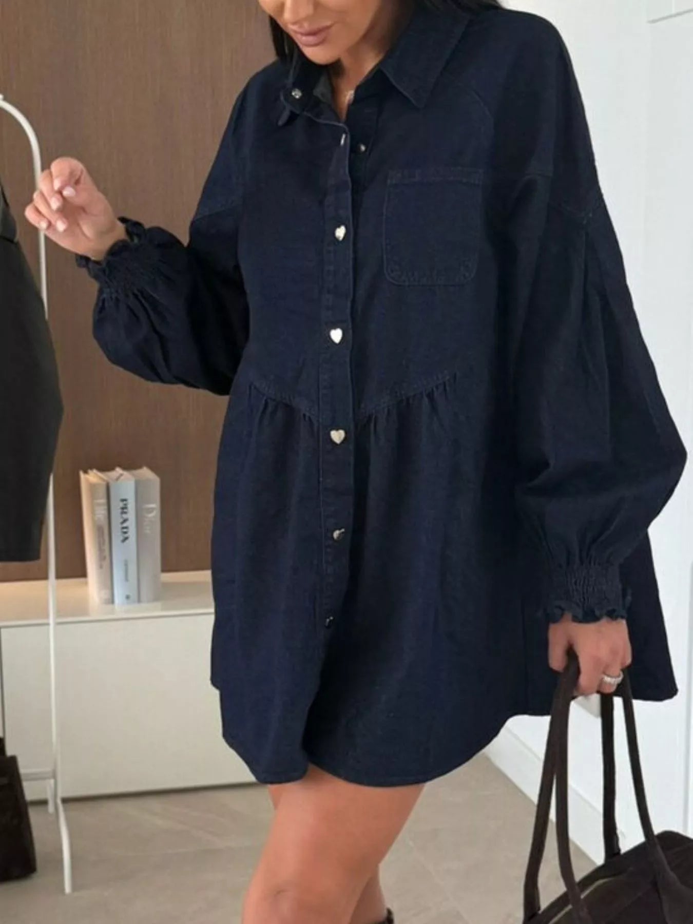 Dark blue denim mini dress with button front, pockets, and voluminous sleeves.