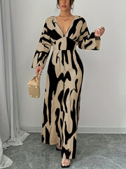Abstract print wide leg jumpsuit with V-neck and belted waist.