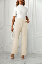 Beige wide-leg trousers with a sculpted waist and pockets.