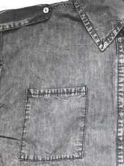 Sleeveless dark gray denim utility shirt with collared neckline and buttoned chest pocket.