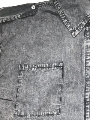 Sleeveless dark gray denim utility shirt with collared neckline and buttoned chest pocket.