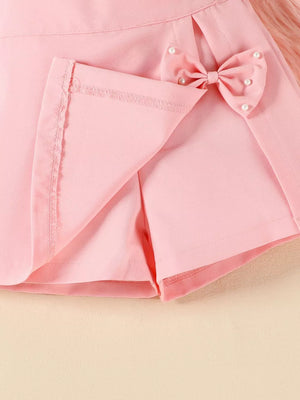 Pink baby skort with bow applique and pearl details.