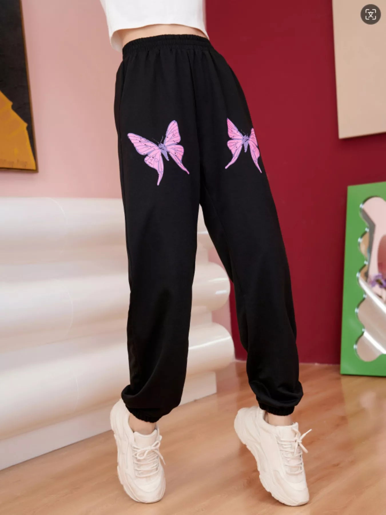 Black sweatpants with pink butterfly graphic detail