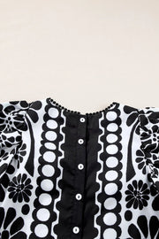 Black floral puff sleeve blouse with button back and pom-pom trim neckline.