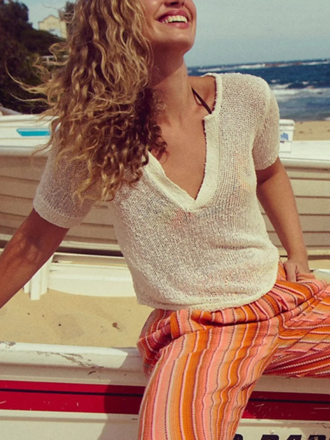 Chic knit sleeve blouse in off-white with a deep V-neck and short sleeves.