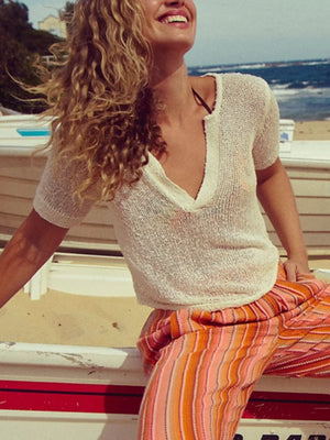 Chic knit sleeve blouse in off-white with a deep V-neck and short sleeves.