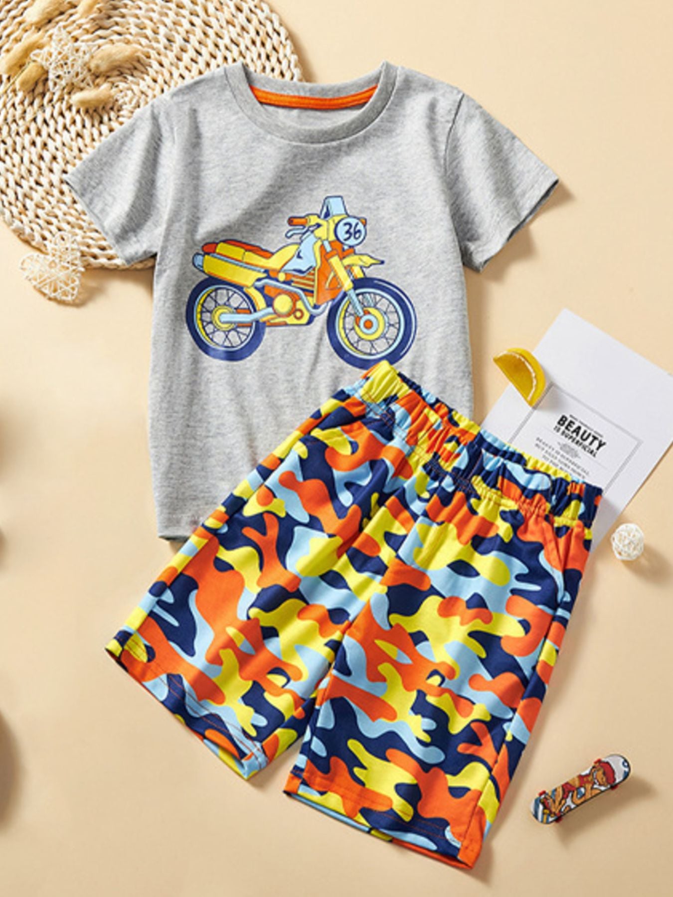Toddler grey cotton t-shirt with motorcycle graphic and colorful camouflage shorts.