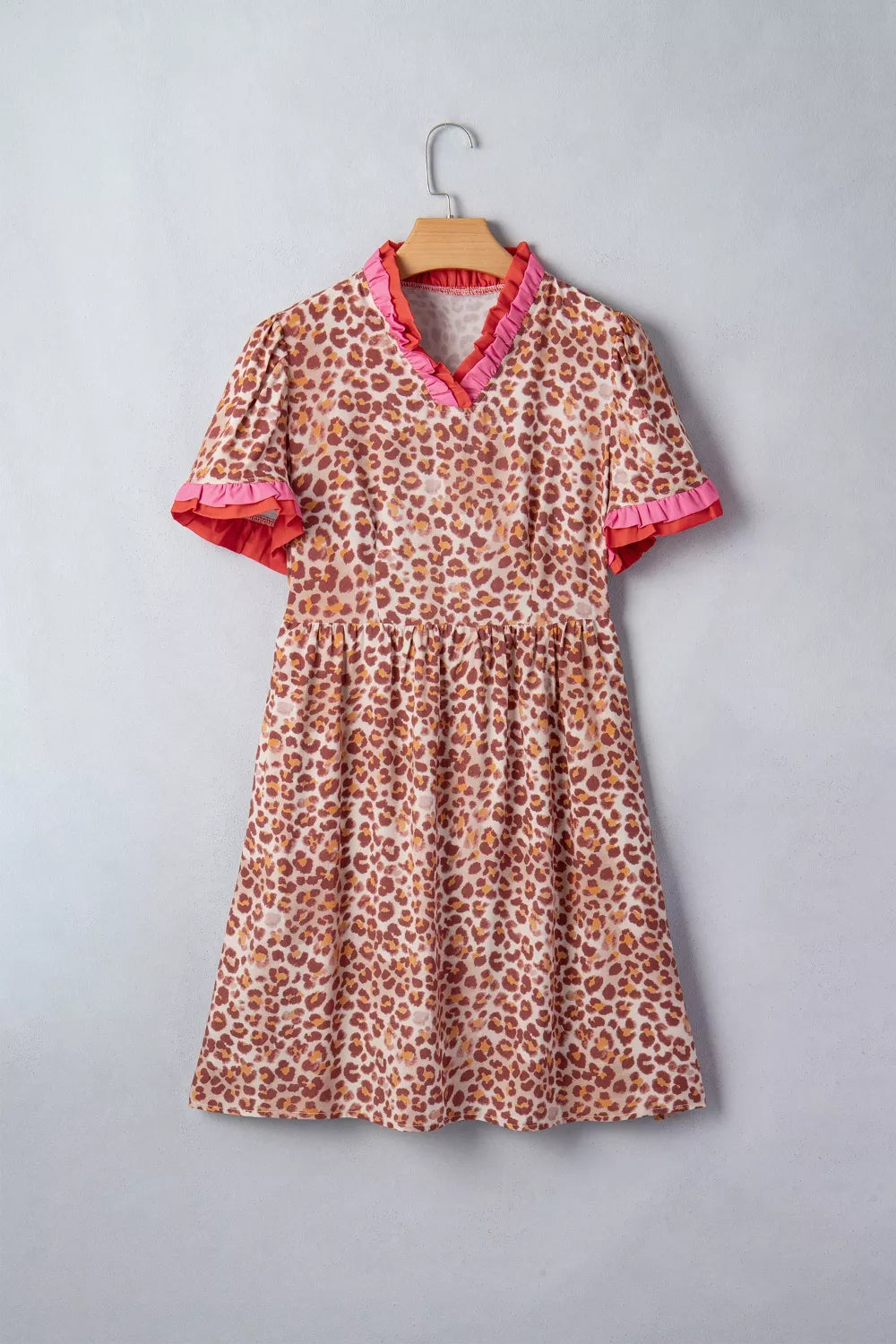 Leopard print dress with ruffled V-neck and short sleeves.