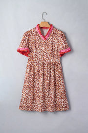 Leopard print dress with ruffled V-neck and short sleeves.