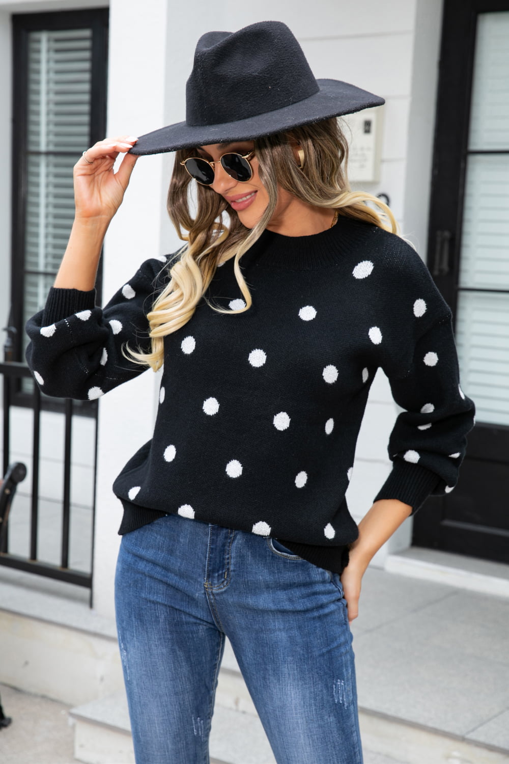 Black polka dot knit sweater with balloon sleeves and crew neck.