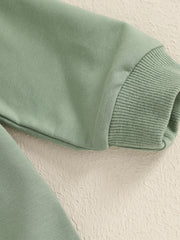 Green cotton baby outfit with ribbed cuffs and applique detail.