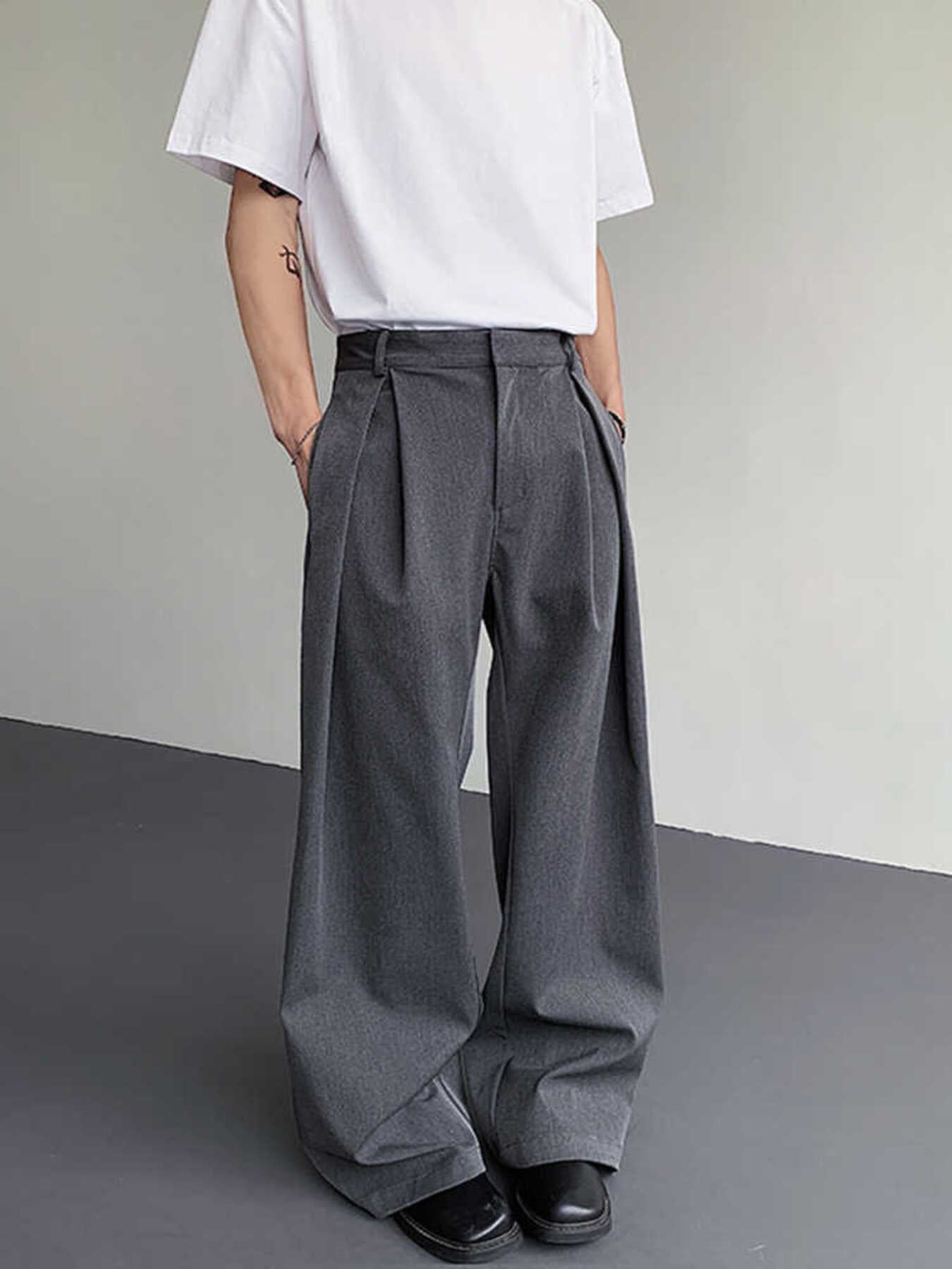 Men's relaxed fit grey sweatpants with pleats and wide leg, styled with a white t-shirt.