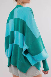 Checkerboard knit oversized sweater in turquoise and green with a collar and wide sleeves.