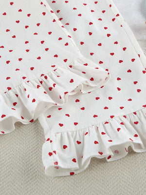 White cotton pajama set with red heart pattern and ruffled trim.