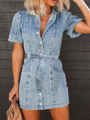 Belted denim mini dress with puff sleeves and button front in medium wash.