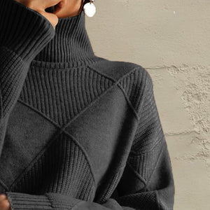 Black turtleneck pullover with diamond knit texture and ribbed sleeves.