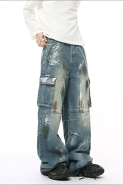 Artisan denim cargo pants in medium wash with paint splatters and wide legs.