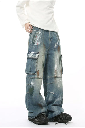 Artisan denim cargo pants in medium wash with paint splatters and wide legs.