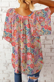Floral dolman sleeve blouse with a gathered neckline and vibrant floral print.