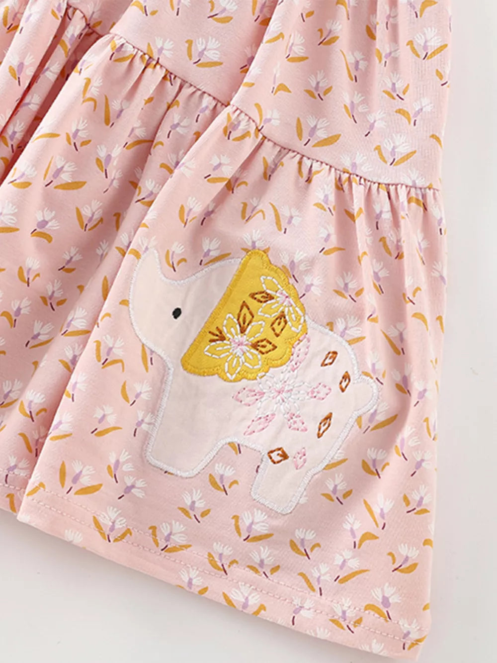 Toddler dress with pink floral print, elephant applique, and ruffle detail.