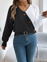 Asymmetrical colorblock knit sweater in black and white with button details.