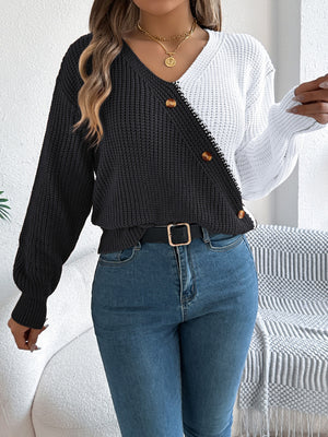 Asymmetrical colorblock knit sweater in black and white with button details.