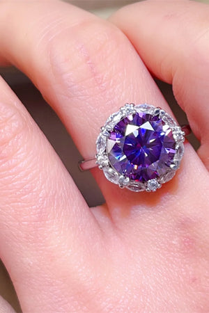 Amethyst halo cocktail ring in silver with a large faceted purple stone surrounded by small clear stones.