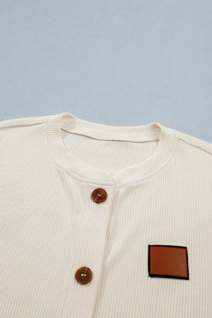 Cream ribbed knit maternity shirt with button front and faux leather patch detail.