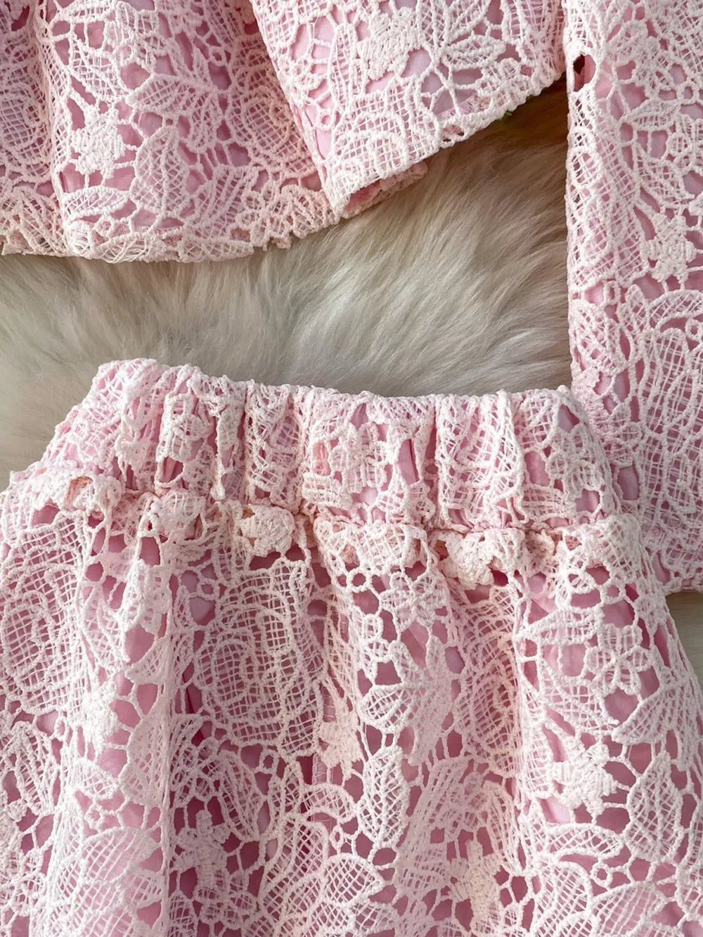 Blush pink lace two-piece ensemble with peplum detail and elastic waist skirt.