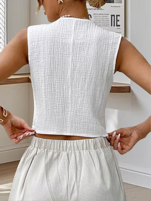 White textured cropped vest with tortoiseshell buttons, sleeveless, high neck