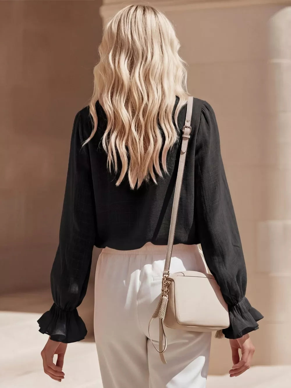 Black maternity shirt with ruffled cuffs and V-neck detail.