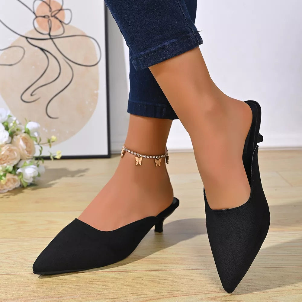 Black pointed-toe kitten heel mules with a delicate butterfly anklet.