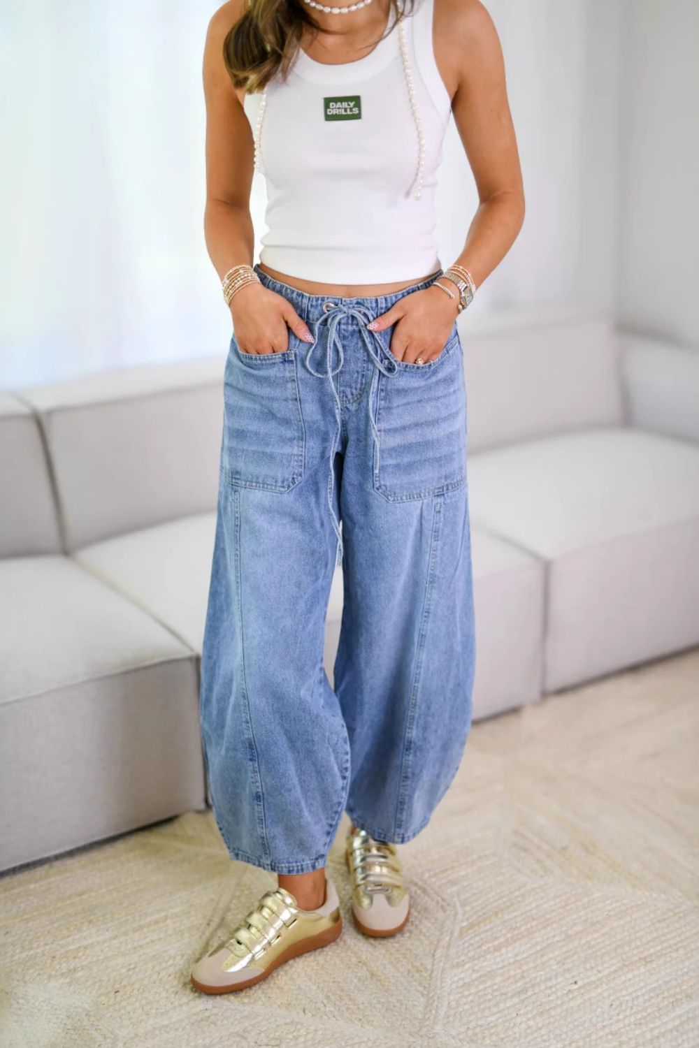 Light wash denim balloon-leg jeans with drawstring waist and utility pockets