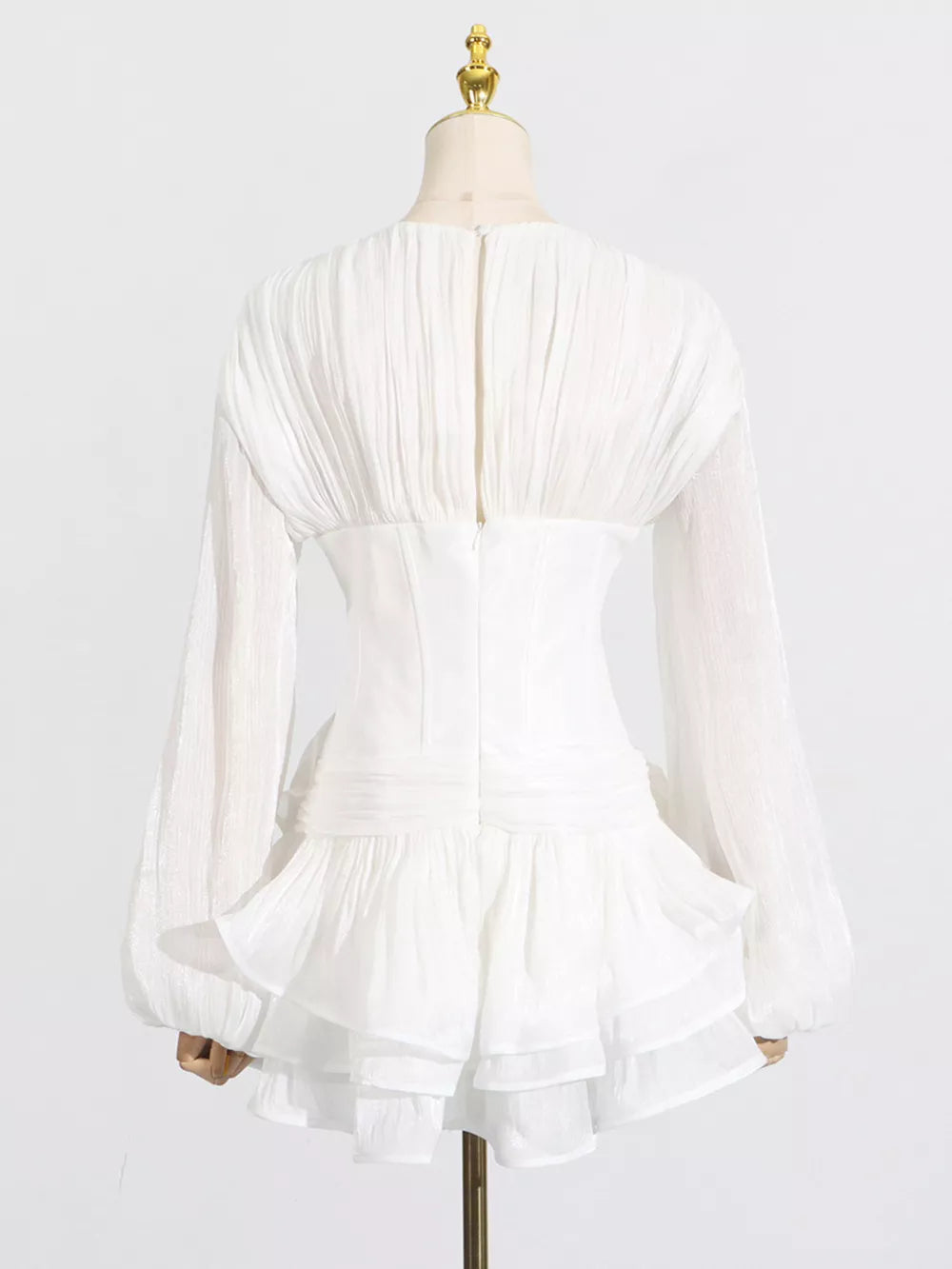 White ruffle mini dress with balloon sleeves and ruched back detail.