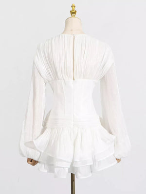 White ruffle mini dress with balloon sleeves and ruched back detail.